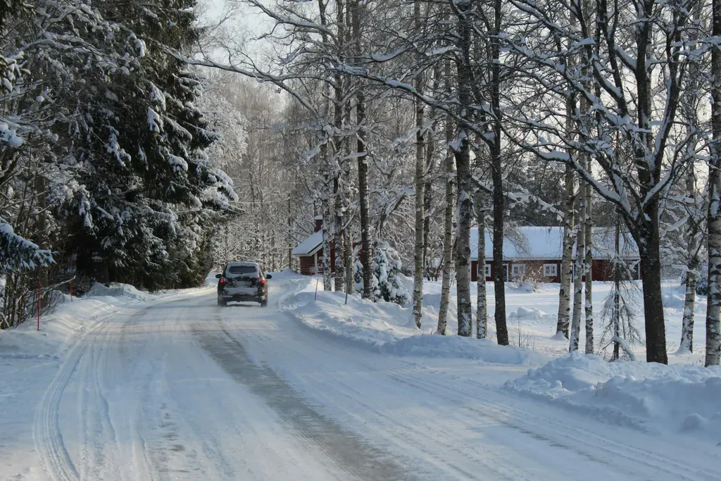 black car on road covered with snow during daytime