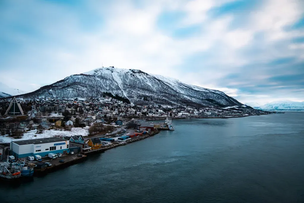 Snowy mountain overlooks a coastal town and harbor