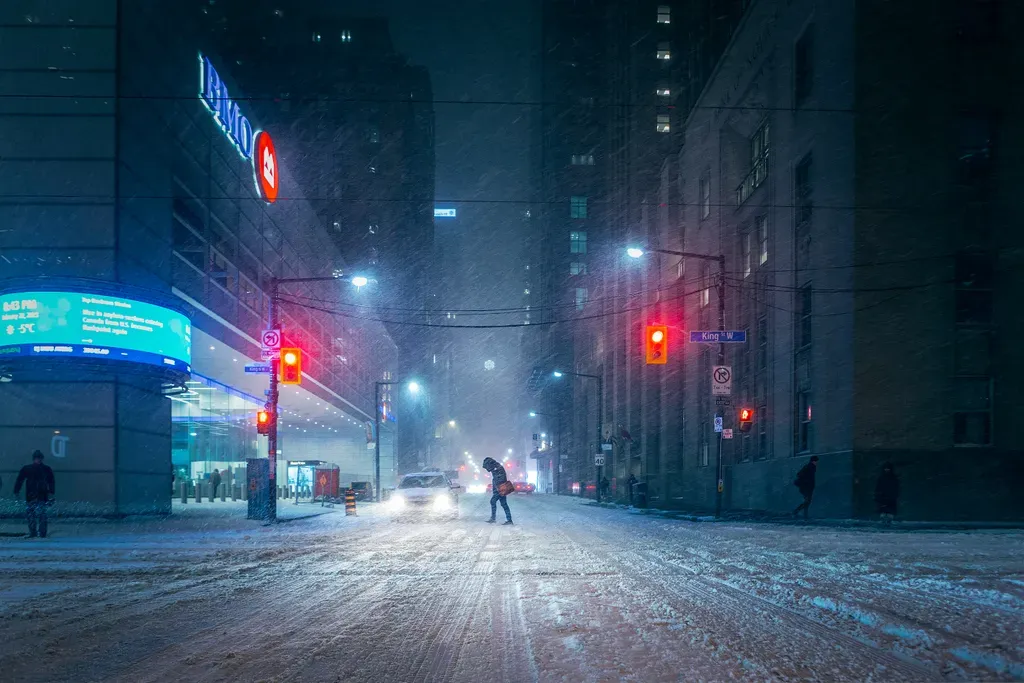 a couple of people walking across a snow covered street