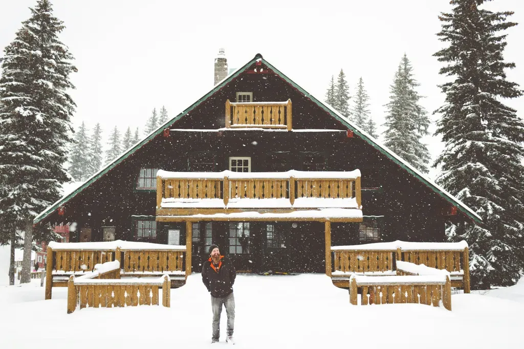 person standing beside brown wooden house during daytime